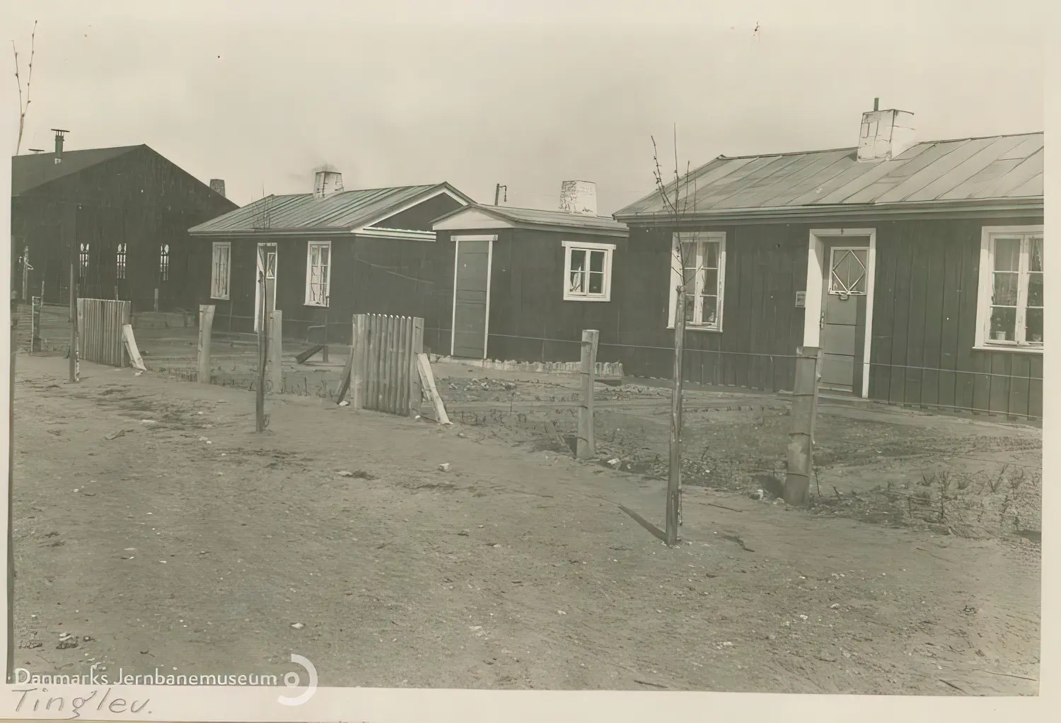 Billede af midlertidige boliger for jernbanefolk til Tinglev Station efter Genforeningen. Svellehuse på Birkeallé, set mod øst. I baggrunden tv. lokomotivremisen.