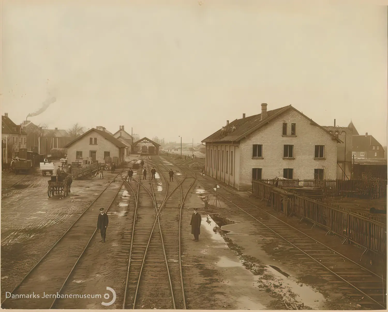 Billede af udsigt mod vest over Nakskov Station. Den gamle lokomotivremise er under nedrivning og sporarealet ændres i anledning af Nakskov - Kragenæs Jernbanes (NKJ) indføring.