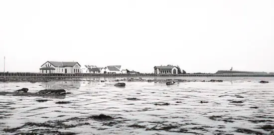 Billede af Knudshoved Station omkring 1899 set fra vest med stationsbygningen til venstre og remisen til højre. Det tidligere fyr ses også. Det nuværende fyrtårn er fra 1948 og noget højere. Til gengæld er fyrbakken blevet mindre. Sporet fortsætter mod Slipshavn