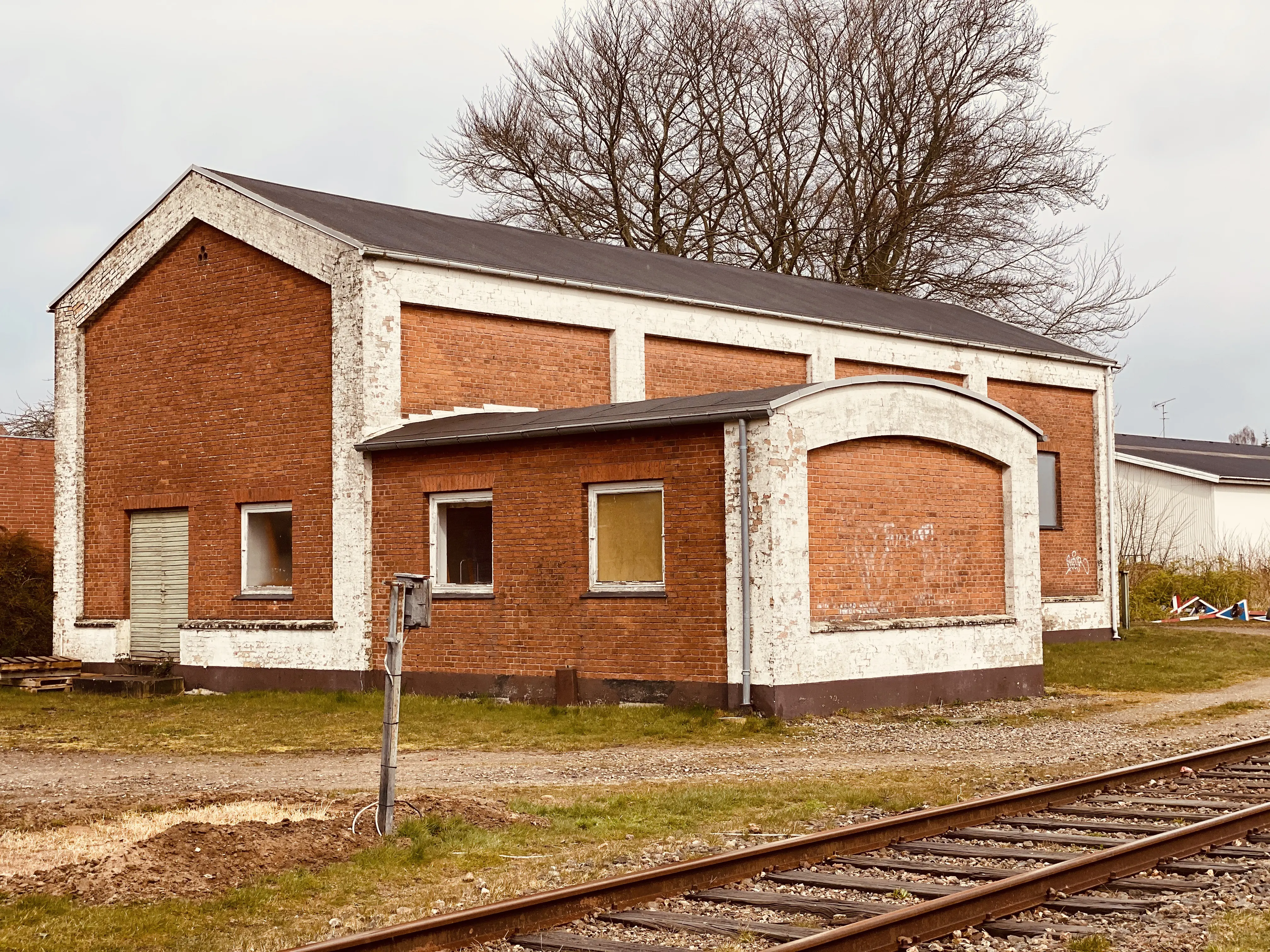 Billede af Haderslev Vestbanegård, som blev nedrevet 1985 (Stationsbygningen), men motorremisen fra 1951 eksistere stadig i 2020.