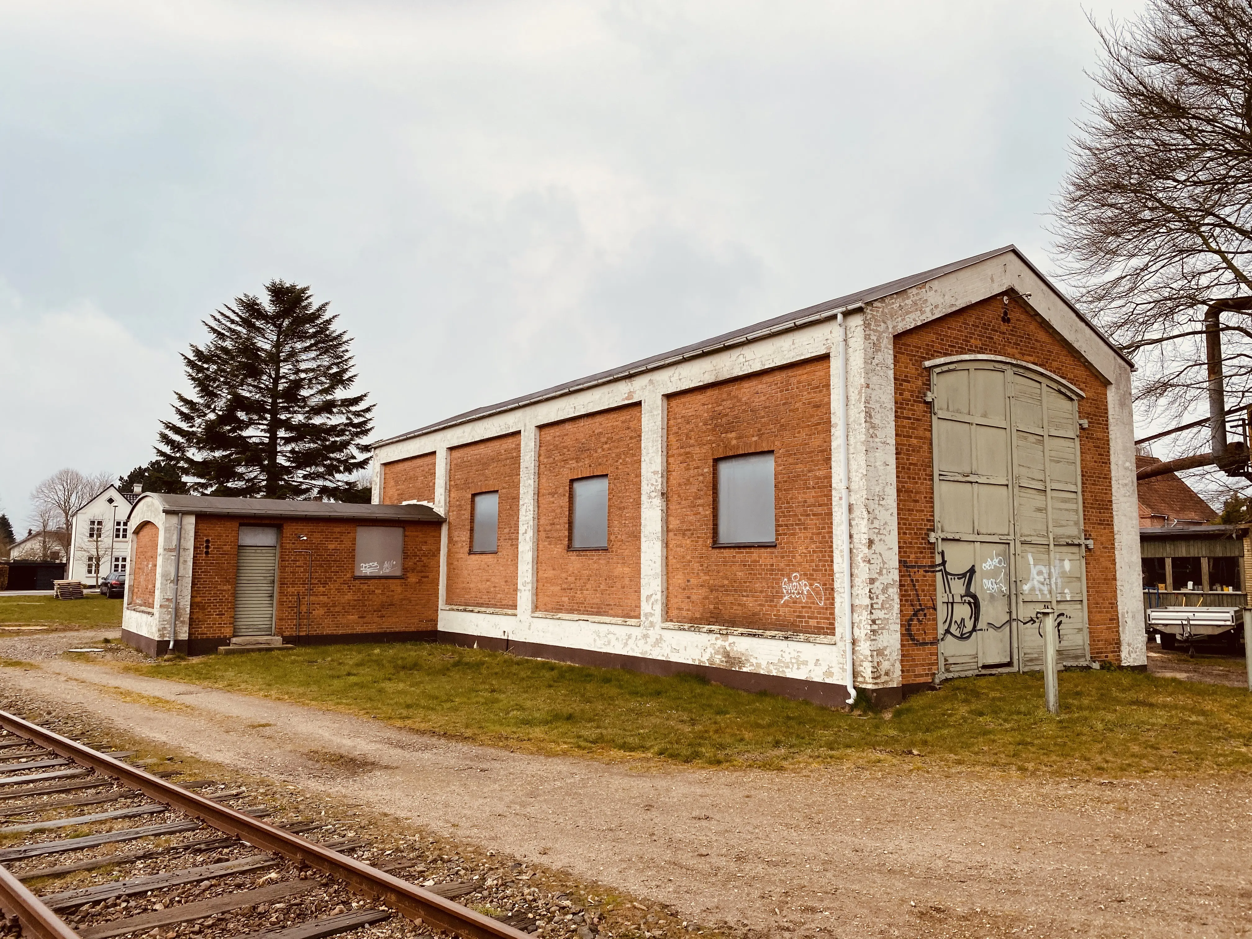 Billede af Haderslev Vestbanegård, som blev nedrevet 1985 (Stationsbygningen), men motorremisen fra 1951 eksistere stadig i 2020.