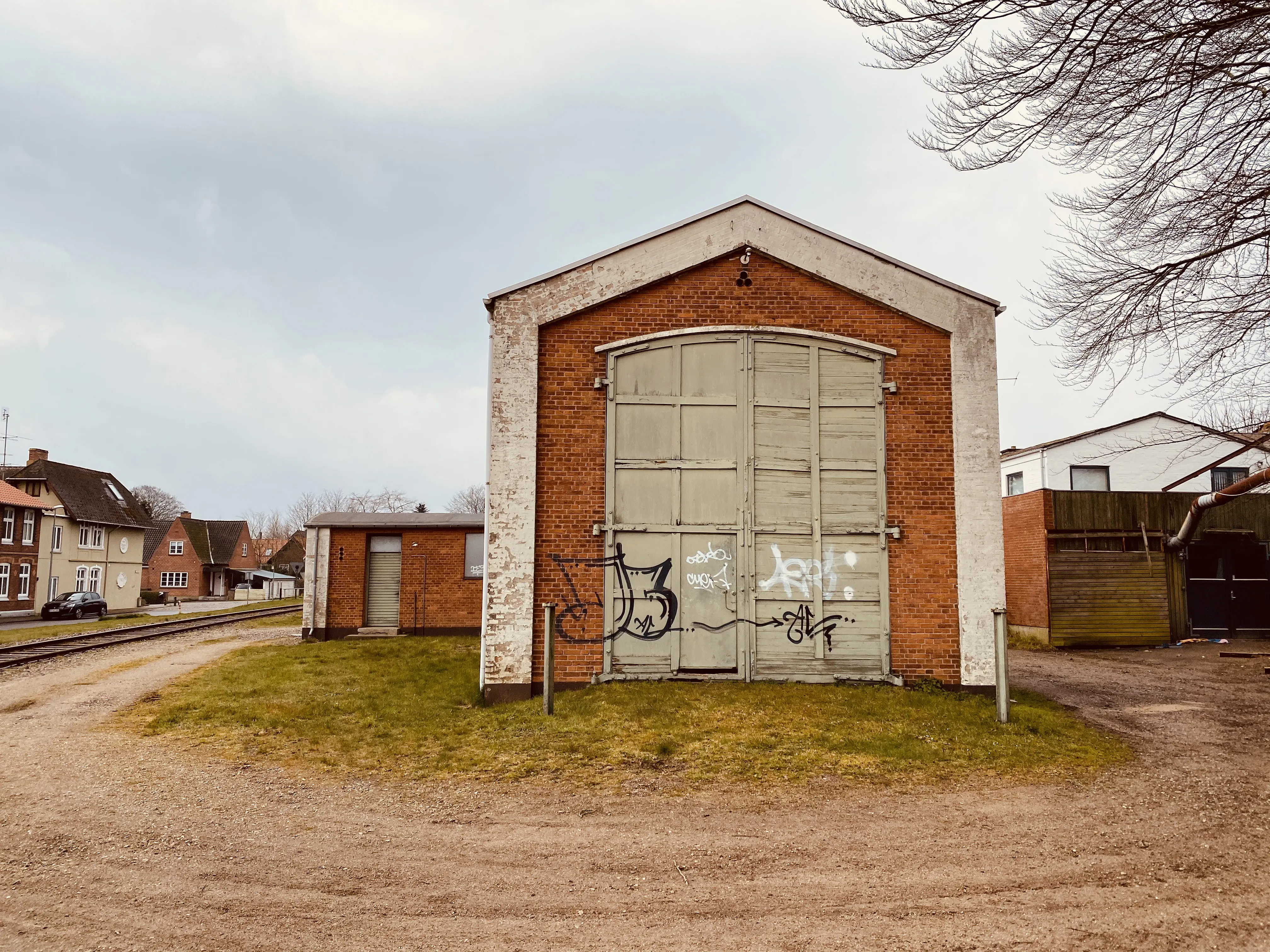 Billede af Haderslev Vestbanegård, som blev nedrevet 1985 (Stationsbygningen), men motorremisen fra 1951 eksistere stadig i 2020.