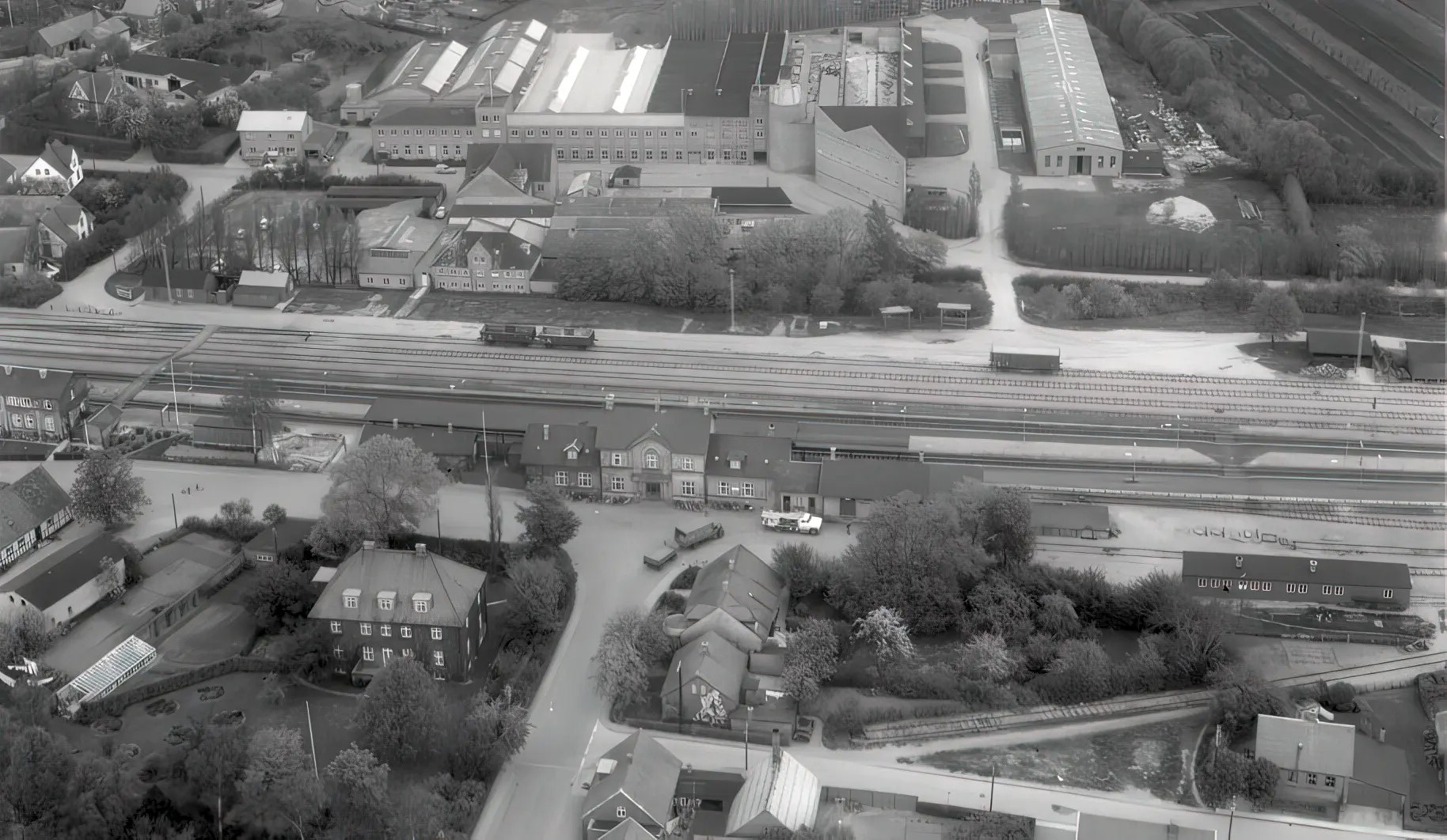 Billede af Tommerup Station (1865-1883) er placeret til venstre for midten og stationen fra 1883 i midten. Billede af Tommerup Station (1865-1883) er placeret til venstre for midten og stationen fra 1883 i midten.