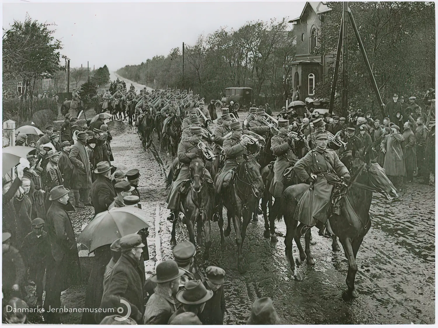 I øsende regnvejr passerer danske dragonstyrker på vej mod Tønder grænsen ved Vedsted-Hvidding Station.