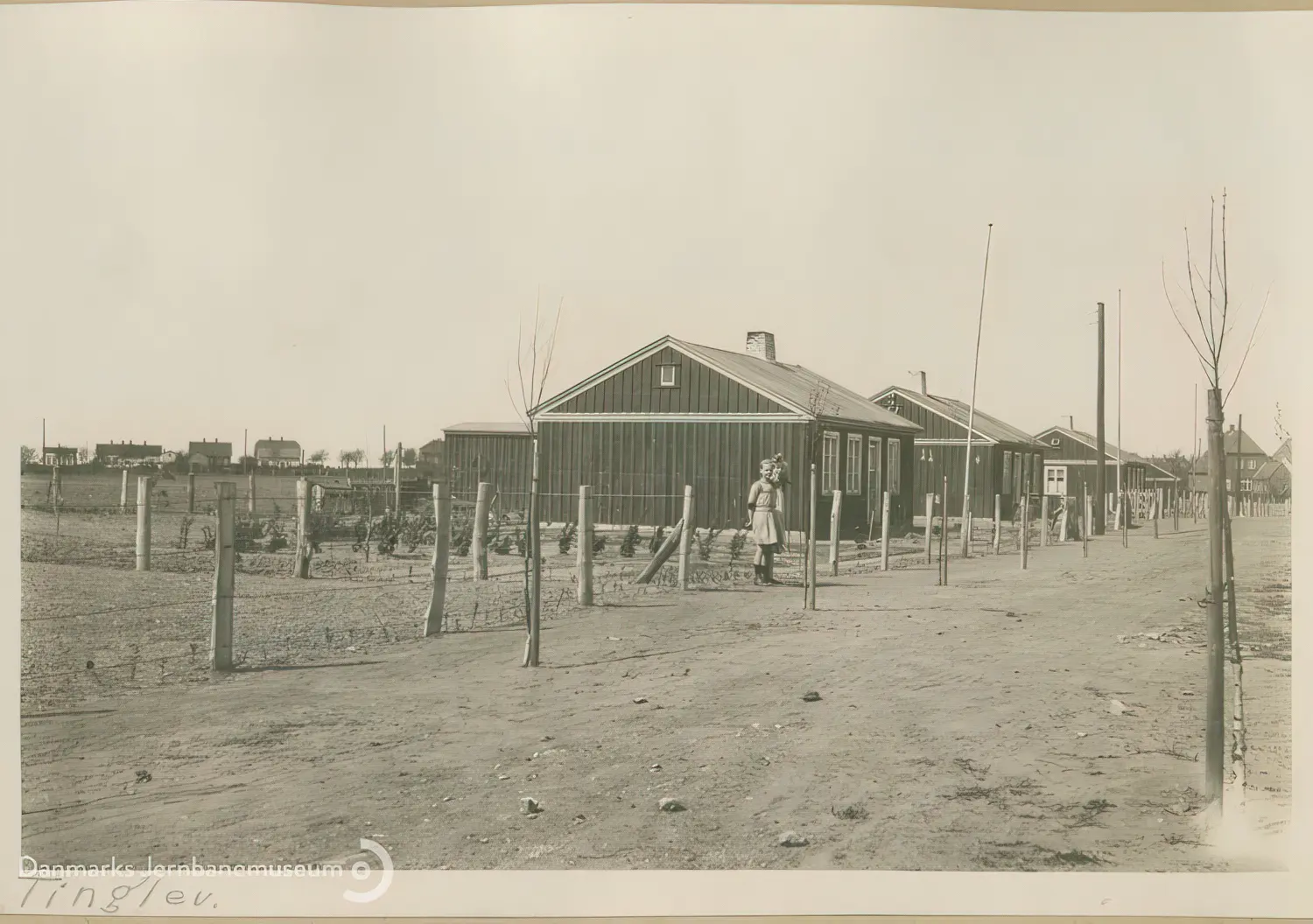 Billede af midlertidige boliger for jernbanefolk til Tinglev Station efter Genforeningen. Svellehuse på Birkeallé, set mod nord. Billede af midlertidige boliger for jernbanefolk til Tinglev Station efter Genforeningen. Svellehuse på Birkeallé, set mod nord.