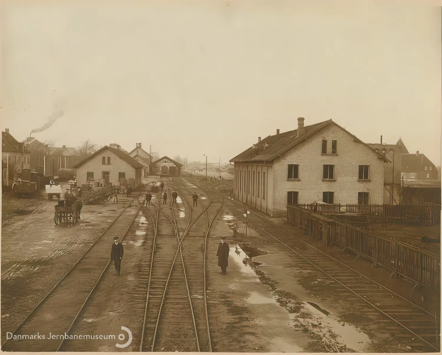 Billede af udsigt mod vest over Nakskov Station. Den gamle lokomotivremise er under nedrivning og sporarealet ændres i anledning af Nakskov - Kragenæs Jernbanes (NKJ) indføring. Billede af udsigt mod vest over Nakskov Station. Den gamle lokomotivremise er under nedrivning og sporarealet ændres i anledning af Nakskov - Kragenæs Jernbanes (NKJ) indføring.