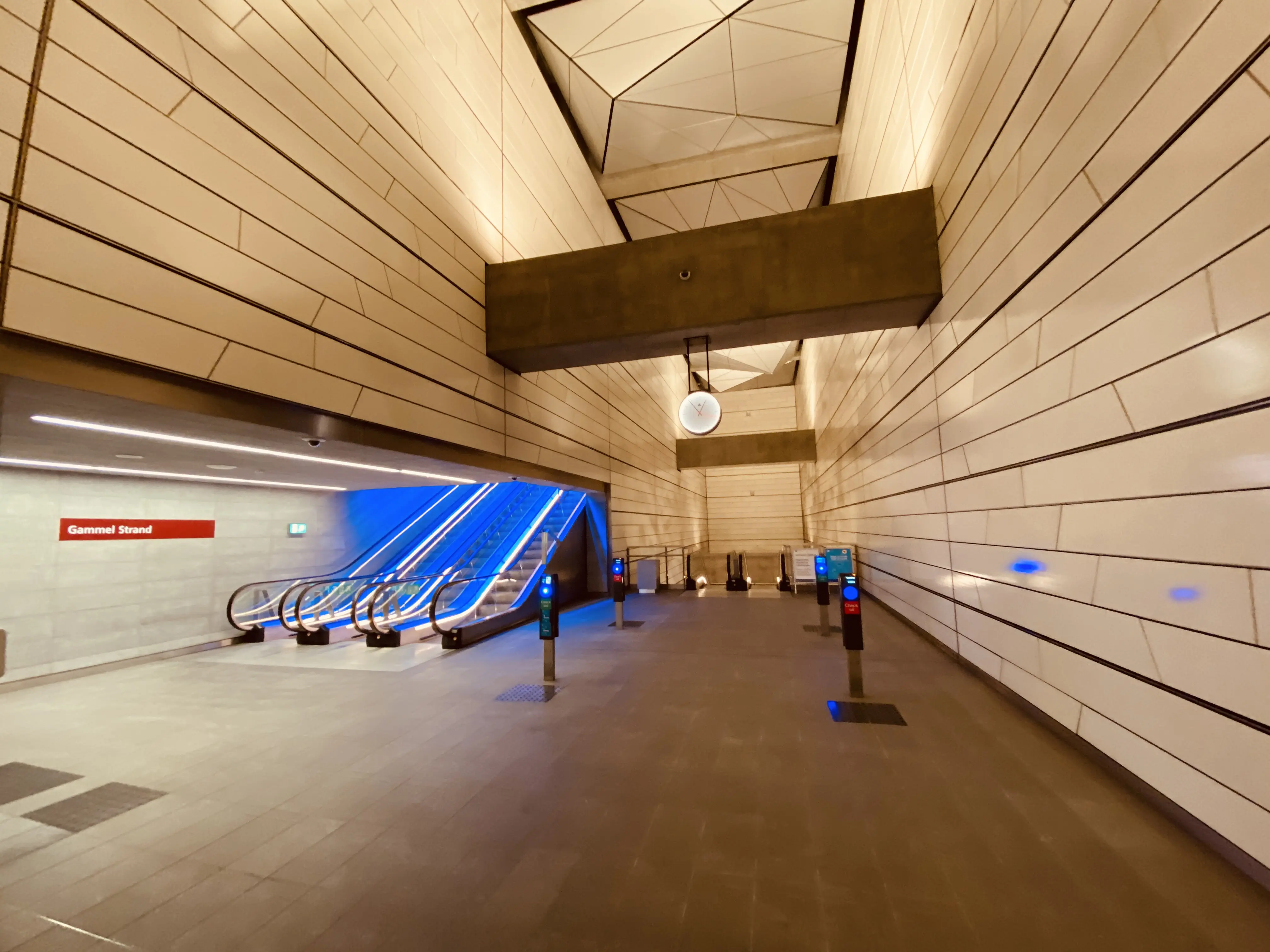 Billede af Gammel Strand Metrostation med et blåt lysspil, som er en hilsen til sollyset i vandoverfladen i Gammel Strands kanal, der løber lige ved siden af stationen.