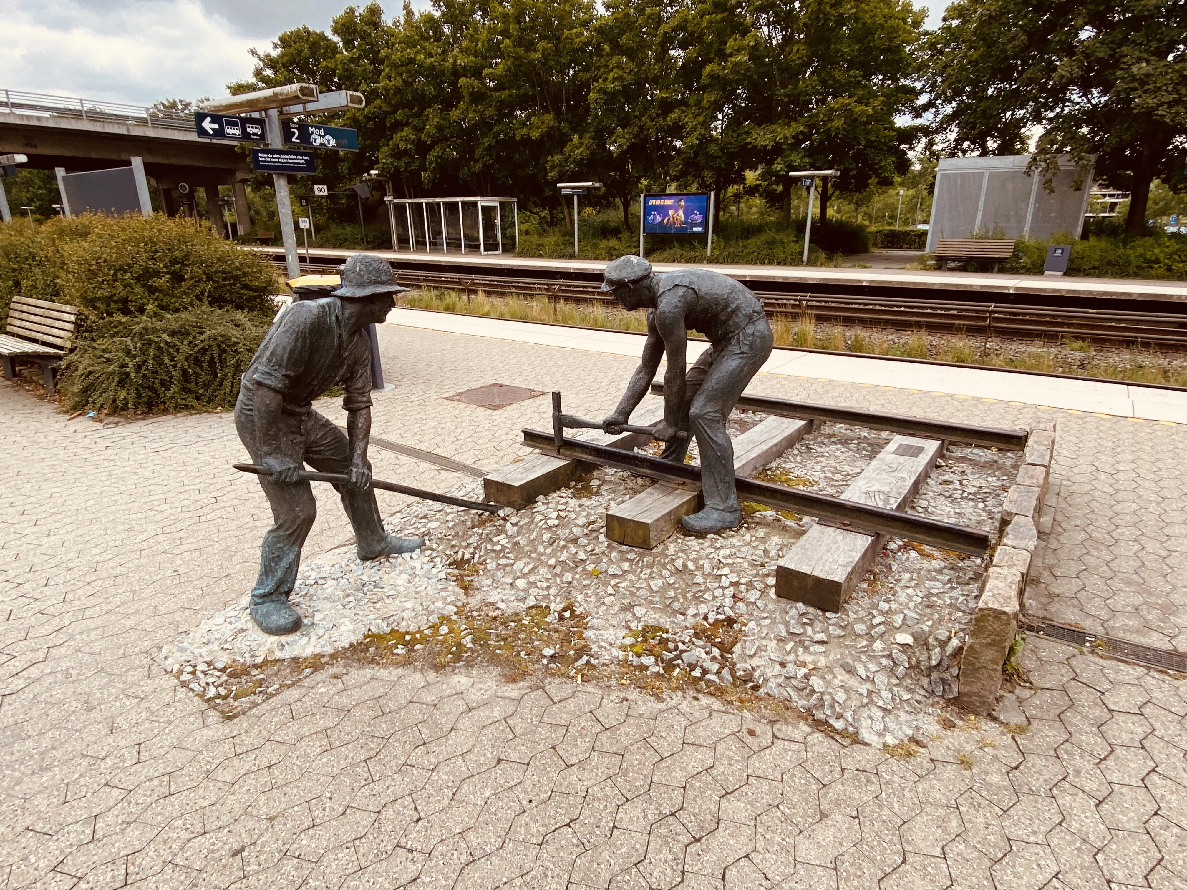 Billede af skulpturen af jernbanebørsterne ved den nye Hadsten Stations stationsbygning i Hadsten. Billede af skulpturen af jernbanebørsterne ved den nye Hadsten Stations stationsbygning i Hadsten.