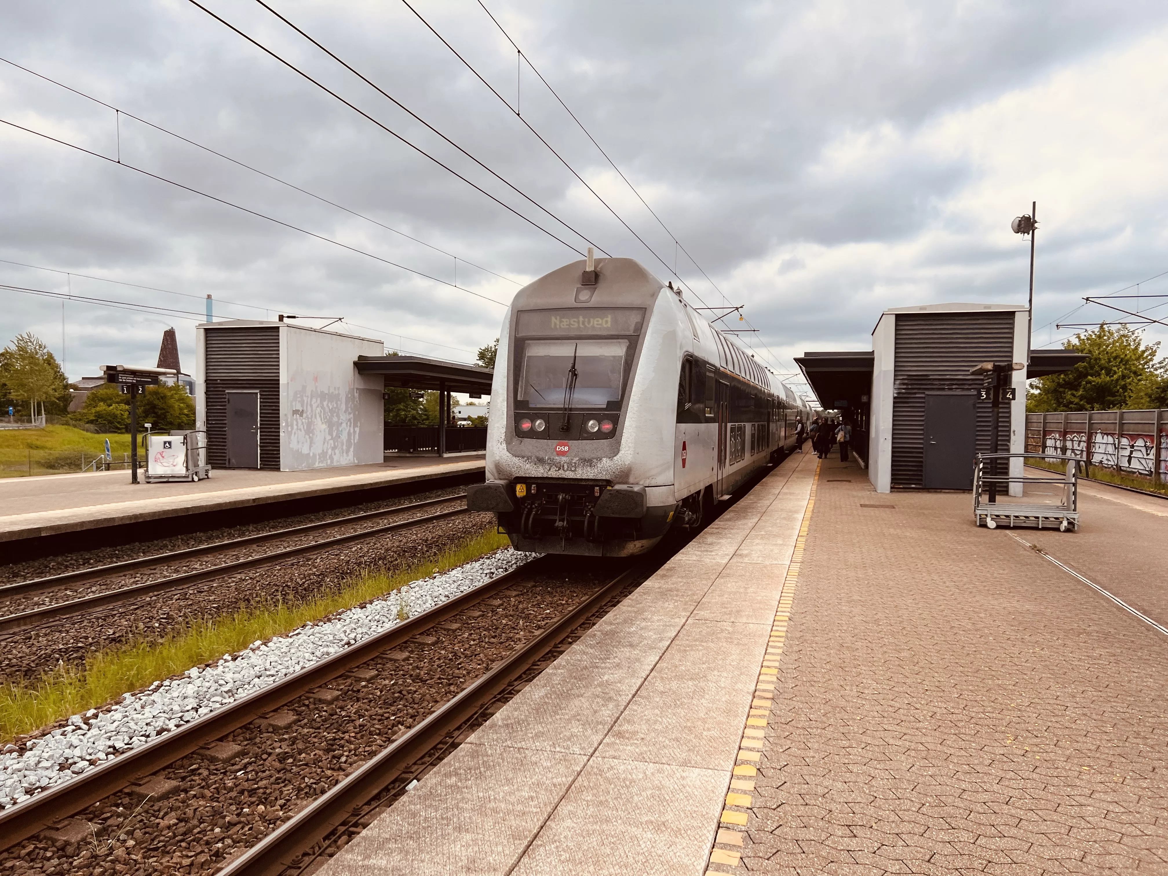 Billede af tog ud for Trekroner Trinbræt. Billede af tog ud for Trekroner Trinbræt.