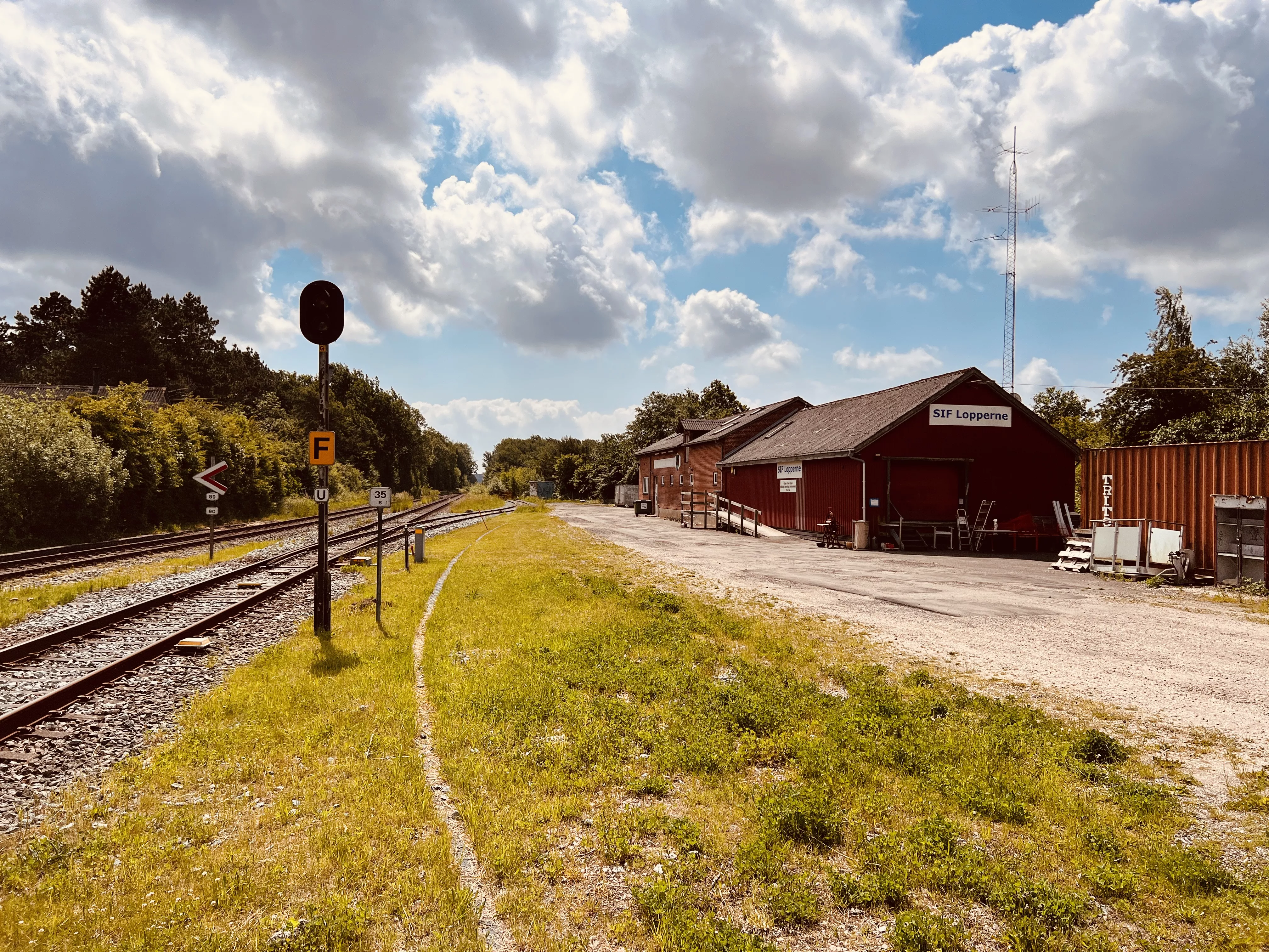 Billede af Stenstrup Trinbræt med det gamle varehus i baggrunden.