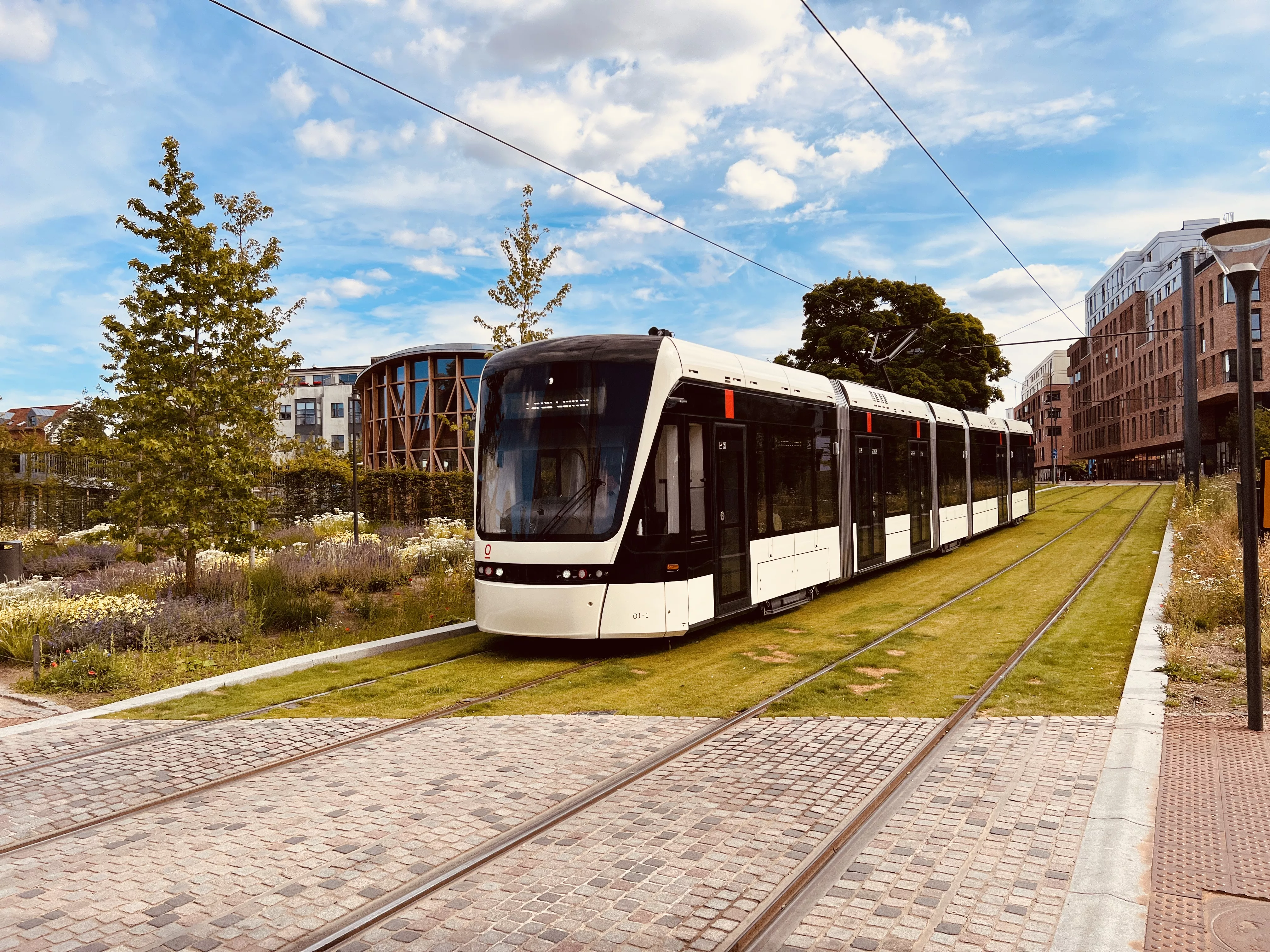 Billede af letbanetog ud for H. C. Andersens Museum og på vej ind på Odeon Letbanestation.