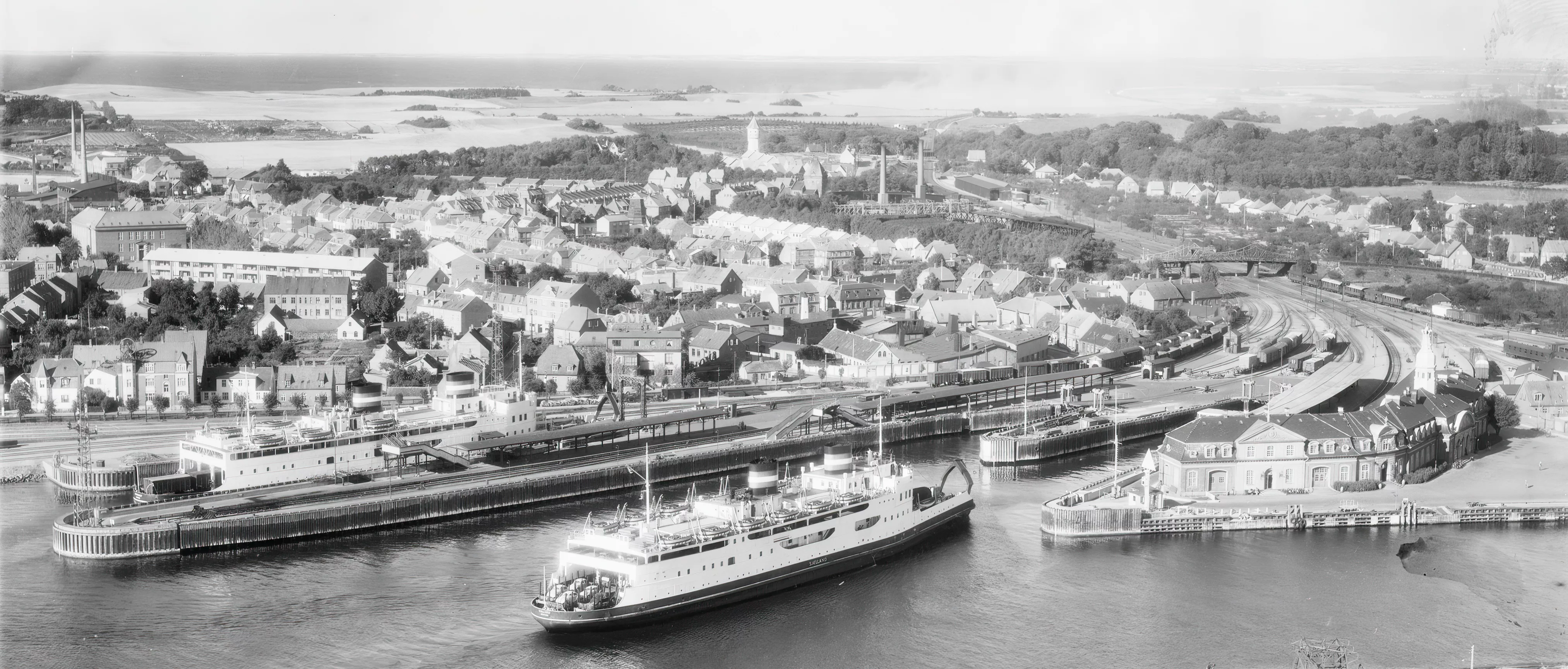 Billede af Korsør Station med færgen Sjælland til venstre for - bemærk lasten af folkevognsbobler på jernbanevognene. Billede af Korsør Station med færgen Sjælland til venstre for - bemærk lasten af folkevognsbobler på jernbanevognene.