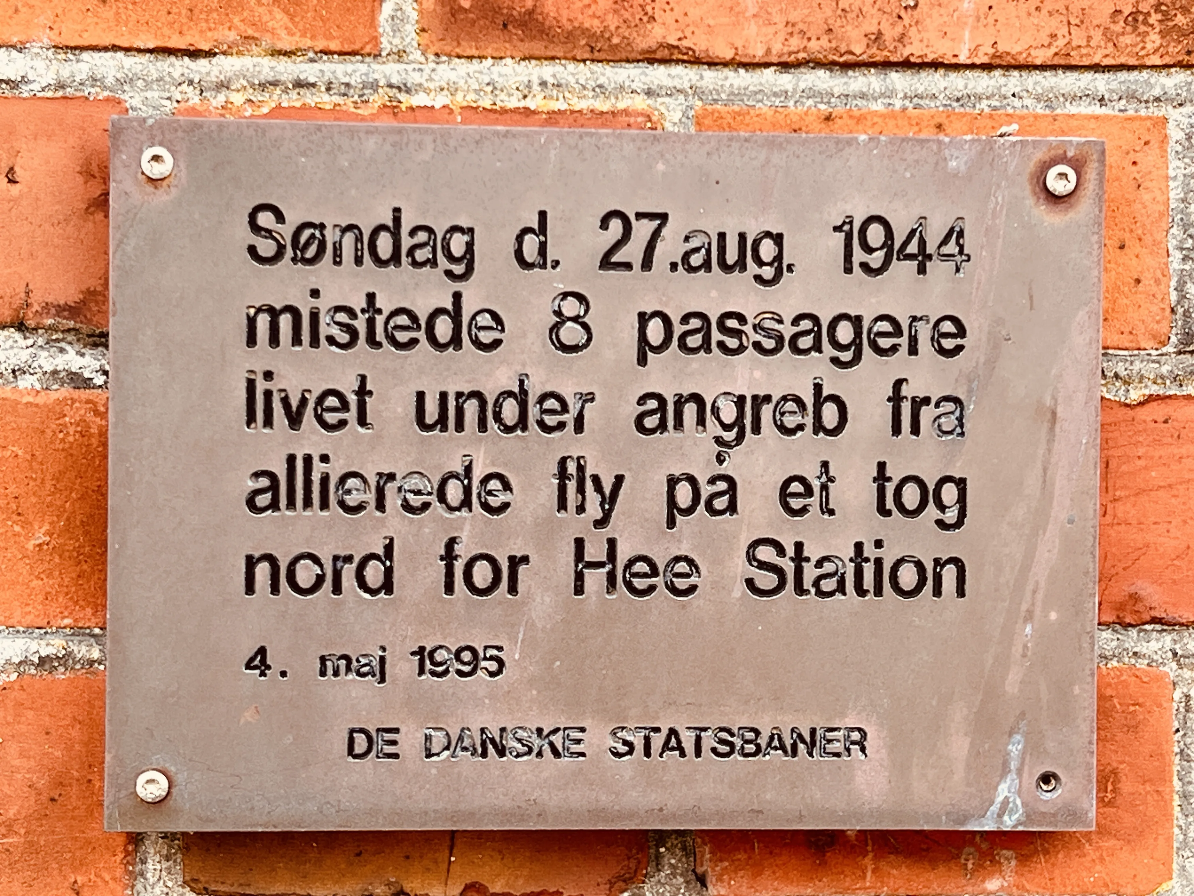 Billede af mindepladen på Hee Station - 8 passagerer mistede livet under et angreb på et tog den 27. august 1944. Billede af mindepladen på Hee Station - 8 passagerer mistede livet under et angreb på et tog den 27. august 1944.